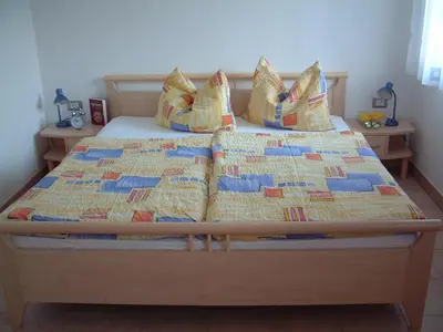 a bed with a quilt and pillows on it at Residence Hofer in Valdaora