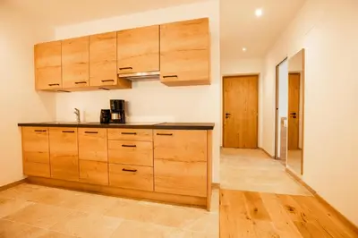 a kitchen with wooden cabinets and wooden floors at Lahnhof in Lana