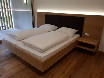 a bed with white sheets and pillows on it at Lahnhof in Lana