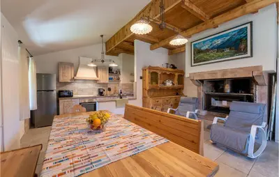 a kitchen and dining room with a table and a fireplace at Beautiful Home In Castello Tesino in Castello Tesino