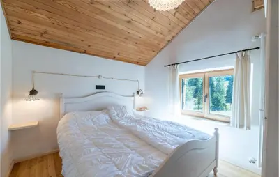 a bedroom with a white bed with a wooden ceiling at Beautiful Home In Castello Tesino in Castello Tesino