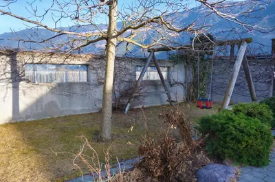 a house with a tree and a swing at Hof Schupfer - Alpstay in Naturno