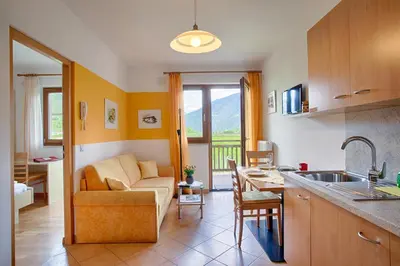 a kitchen and living room with a couch and a table at Hof Schupfer - Alpstay in Naturno
