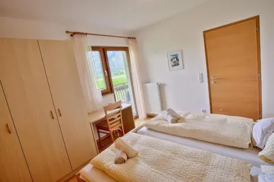 a bedroom with two beds and a window at Hof Schupfer - Alpstay in Naturno