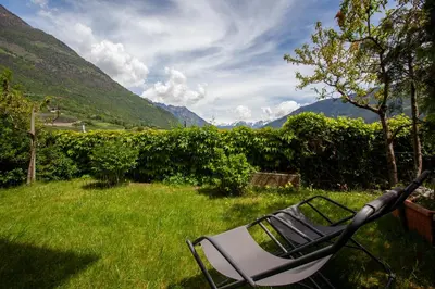 a chair sitting in the grass in a field at Hof Schupfer - Alpstay in Naturno