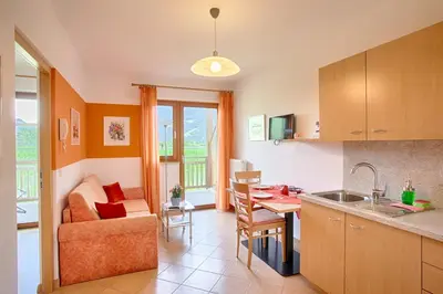 a kitchen and living room with a table and a couch at Hof Schupfer - Alpstay in Naturno