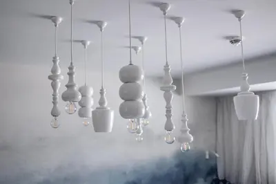 a group of white lights hanging from a ceiling at Loom in Bolzano