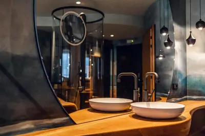 two white bowls on a wooden counter with a mirror at Loom in Bolzano