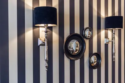 a wall with two mirrors and a lamp on a wall at Loom in Bolzano