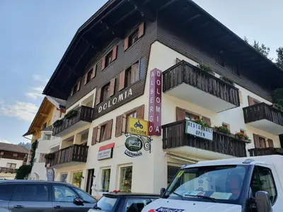 a building with cars parked in front of it at ALBERGO BAR RISTORANTE DOLOMIA in Badia