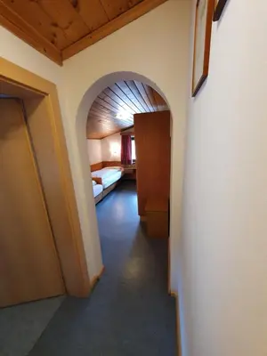 a hallway with a room with a bed and an archway at ALBERGO BAR RISTORANTE DOLOMIA in Badia