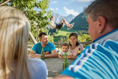 a group of people sitting around a table at Nuierhof in Castelrotto