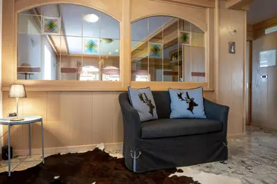 a living room with a chair and a window at Albergo Dolomiti in Cavalese
