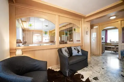 a living room with a chair and a window at Albergo Dolomiti in Cavalese