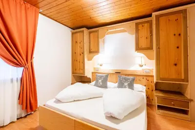 a bedroom with two beds and a window at Albergo Dolomiti in Cavalese