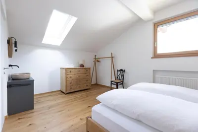 a bedroom with two beds and a window and a dresser at Valentinhof - organic farm in Merano