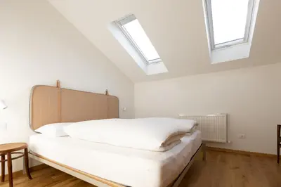 a bedroom with a bed with skylights in it at Valentinhof - organic farm in Merano