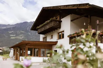 a building with a balcony and flowers on it at Valentinhof - organic farm in Merano