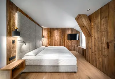 a bedroom with a large bed and wooden walls at Villa Pana in Santa Cristina in Val Gardena