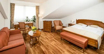 a bedroom with a bed and a living room at Hotel Restaurant Lilie in Vipiteno