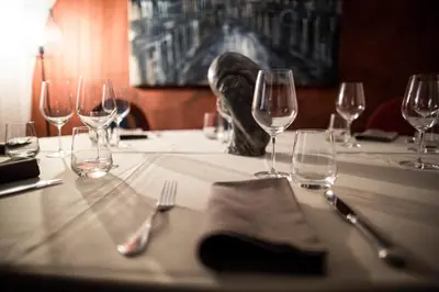 a table with wine glasses and silverware on it at Hotel Restaurant Lilie in Vipiteno