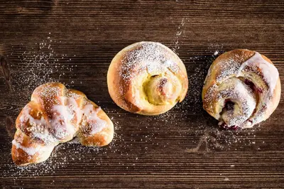 two pastries with powdered sugar on a table at Hotel Restaurant Lilie in Vipiteno
