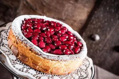 a raspberry cake on a plate on a table at Hotel Restaurant Lilie in Vipiteno