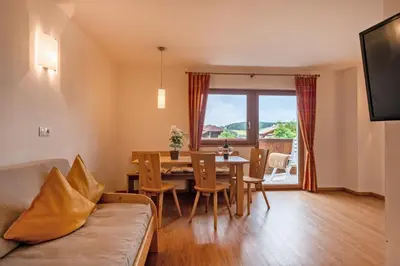 a living room with a table and a dining room at Residence Viktoria in Castelrotto