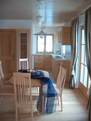 a kitchen with a table and chairs in a room at Ortnerhof in Gais