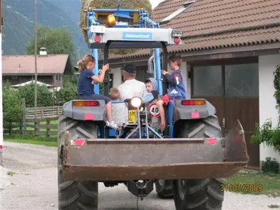 a group of children sitting in the back of a tractor at Ortnerhof in Gais