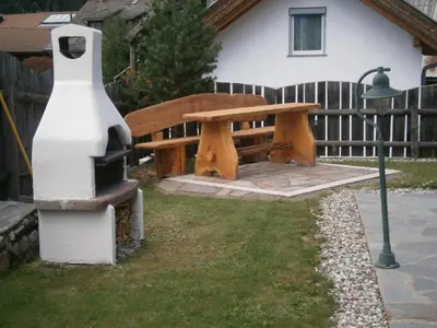 a wooden bench sitting next to a street light at Ortnerhof in Gais