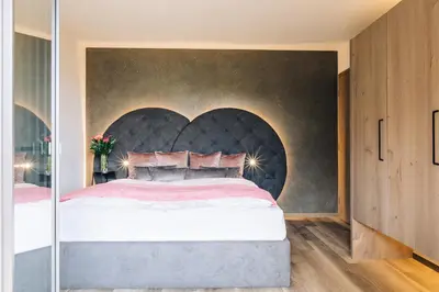 a bedroom with a large bed with a heart shaped headboard at La Rosea - Fine Living Apartments in Appiano sulla Strada del Vino
