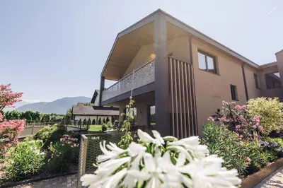 a house with flowers in front of it at La Rosea - Fine Living Apartments in Appiano sulla Strada del Vino