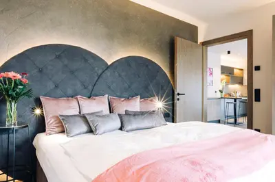 a bedroom with a large bed with a large headboard at La Rosea - Fine Living Apartments in Appiano sulla Strada del Vino