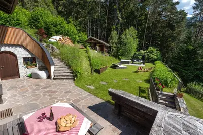 a backyard with a bench and a table with food on it at Villa Vintila with Whirlpool & Sauna in Vandoies