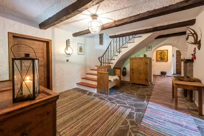 a living room with a staircase and a living room with a couch at Villa Vintila with Whirlpool & Sauna in Vandoies