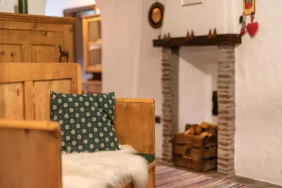 a living room with a chair and a fireplace at Villa Vintila with Whirlpool & Sauna in Vandoies
