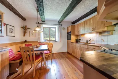 a kitchen with wooden cabinets and a table and chairs at Villa Vintila with Whirlpool & Sauna in Vandoies