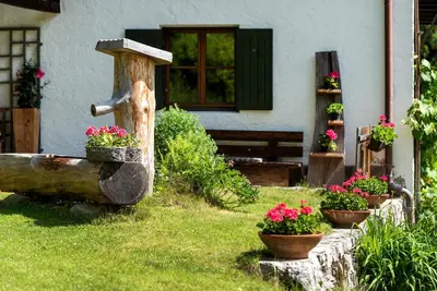 a garden with a water fountain and flowers in a yard at Villa Vintila with Whirlpool & Sauna in Vandoies