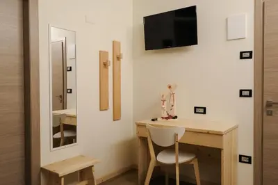 a home office with a desk and a tv on the wall at B&B Le Ciorciole in Tesero