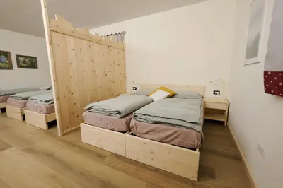 two beds in a room with wooden dividers at B&B Le Ciorciole in Tesero