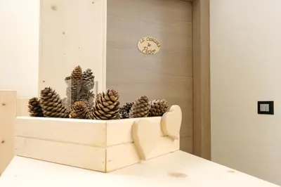 a wooden crate filled with pine cones in front of a clock at B&B Le Ciorciole in Tesero