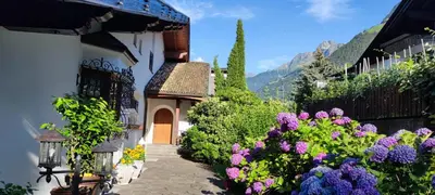 a garden with purple flowers next to a building at Appartements Villa Fortuna in Tirolo