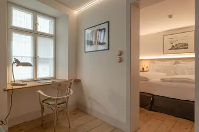 a bedroom with a bed and a desk with a chair at Steinach Townhouse Meran in Merano
