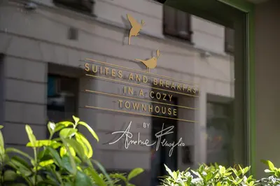 a sign in front of a window with birds on it at Steinach Townhouse Meran in Merano