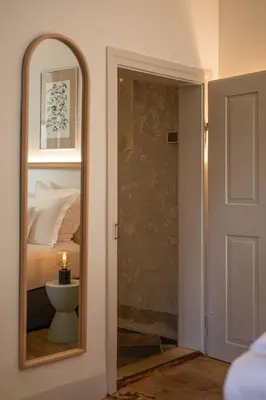 a mirror in a room with a bed and a bedroom at Steinach Townhouse Meran in Merano