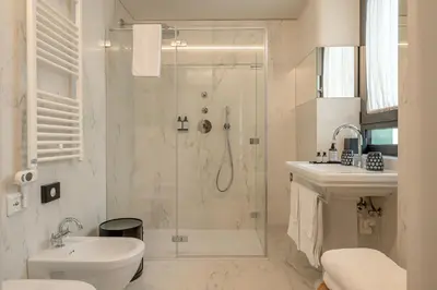 a bathroom with a shower and a toilet and a sink at Steinach Townhouse Meran in Merano