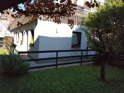 a white building with a black fence next to a yard at Peters Guest House in Bolzano