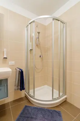 a shower with a glass enclosure in a bathroom at Peters Guest House in Bolzano