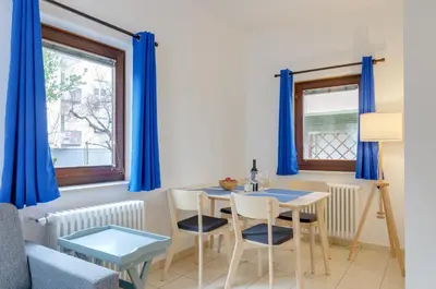 a dining room with blue curtains and a table and chairs at Peters Guest House in Bolzano